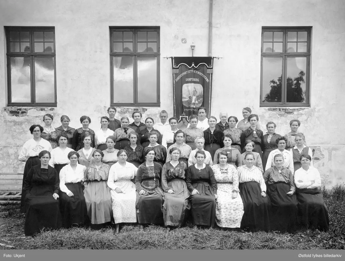 Arbeiderpartiets Kvinneforening i Sarpsborg, ca. 1918-1920.
Dato på fane (årstall ikke synlig)  - foreninga blei stifta i 9.2.1907. 
Fotografert utenfor det gamle Folkets Hus i St:Marie gate 38 Sarpsborg.

I andre rekke nummer 12 fra venstre, er Inga Torp (Kari Torp), som var gift med Oscar Torp, som også var sarping. 
I fjerde rekke fra venstre nr seks: Anna Enge, som var gift med Ludvig Enge, politiker og den første sosialist  fra Østfold på Stortinget. Blei seinere ordfører i Sarpsborg.

Marie Bergine Krogfos Johansen. (1867-1934)
 i tredje rekke nr 2 fra høyre. (Bestemor til Karin Haugen f. Johansen)