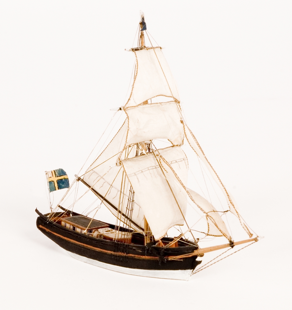 Fartygsmodell, hel i block av trä, vattenlinjemodell, slupen "CRESTIN MARIA" av Kalmar. Segel av bomull. På masttoppen blå vimpel, akterut svensk flagga med äldre unionsmärket. Svartmålat skrov med brun bastingeringslist.Föremålets form: Vattenlinjemodell