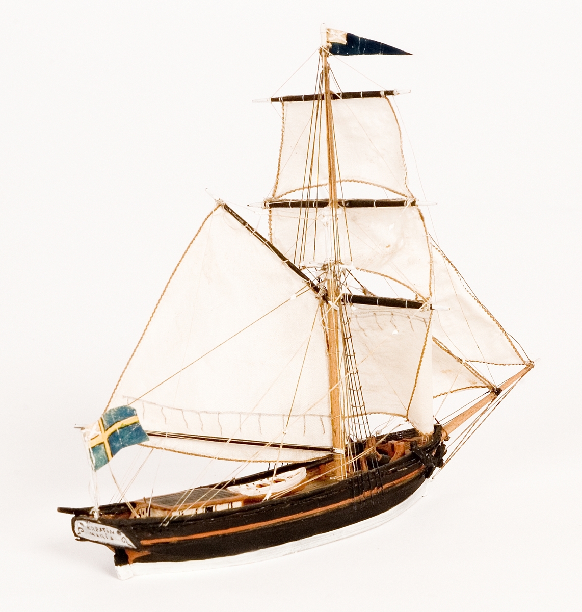 Fartygsmodell, hel i block av trä, vattenlinjemodell, slupen "CRESTIN MARIA" av Kalmar. Segel av bomull. På masttoppen blå vimpel, akterut svensk flagga med äldre unionsmärket. Svartmålat skrov med brun bastingeringslist.Föremålets form: Vattenlinjemodell