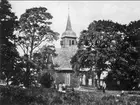 Undenäs, exteriör av gamla kyrkan, den brann ned år 1890. Till höger Frans Stråle av Sjöared, till vänster författare Torsten Fogelqvist och i mitten prosten Heléns döttrar.