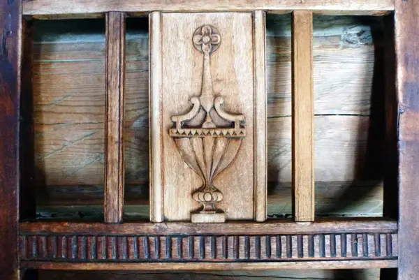 Stolrygg fra amtmannsgarden Steinberg, Toten. Viser typiske empirestiltrekk, en romersk urne eller amfora, vakkert skåret ut i spilen i ryggen til en trestol.