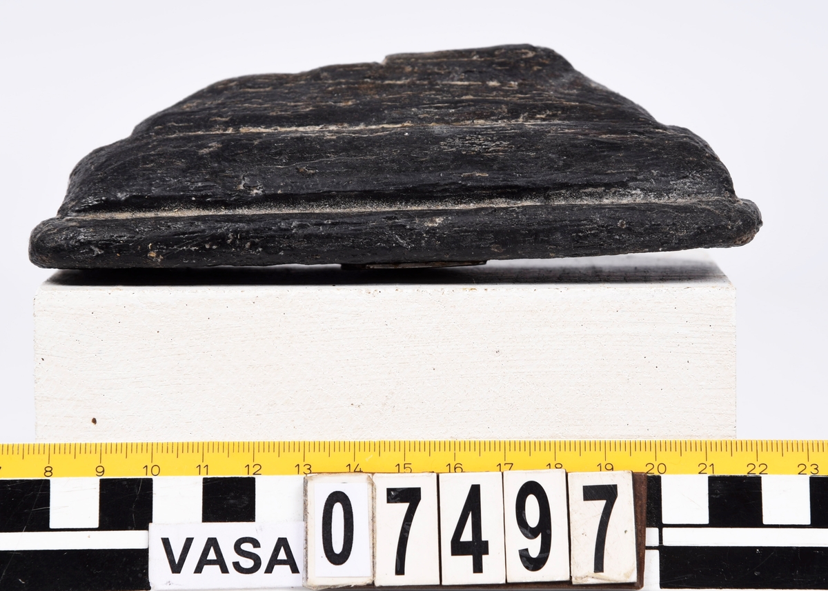 Profilerad sockel i form av en plint, mycket vittrad yta. Övre delen avbruten, kanter och hörn rundade. Profilen dock fortfarande urskiljbar. Ingen saltskada.