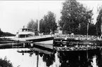 Parti från Göta kanal. Båt passerar rullbron i Rödesund. I bakgrunden kanalhotellet. Båtens namn:Vielle Montagne 11. Foto: T H Hartman år 1931.