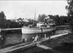 Parti från Göta kanal i Rödesund, passagerarbåten Venus passerar. Sekelskiftet 1800-1900 talet. På vänster sida om kanalen ses grosshandlare Kindboms hus, samt Gyllströmska huset. Förstoring 27 x 35 och 58 x 60 cm. Neg. och glasneg. finns. Foto: Alfred Sjöberg.