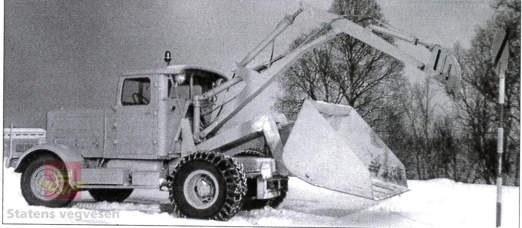 Hanomag SS 100 LN. Ombygd 2 - akslet (4 hjul) maskin med både hydraulisk gravemaskin og lasteskuffe. Gul er hovedfarge (antatt grå originalt). Fra fabrikken ble typen SS 100 LN utstyrt men en vannavkjølt 6-sylindret dieseldrevet motor av typen Hanomag D85S som yter 100 Hk ved 1500 omdreininger. Motorvolum er 8,553 liter. Motornummeret skal være 60386 om motoren er den originale. Maskinens produksjonsnummer er 432528. Girkassen er av typen ZF KB60 med 4 gir framover og ett bakover, pluss overdrive. Topphastighet 65 km/t. Det elektriske anlegget er 24 V. 20 tommers hjul, opprinnelig hadde den tvillinghjul bak. Dører finnes men sitter ikke på.
Har tre merker (stempel) med ørn og hakekors samt plate fra produsenten (på torpedoveggen).
"FROSS-BUSSING" merking i fronten (antatt grill fra en Fross- Bussing).