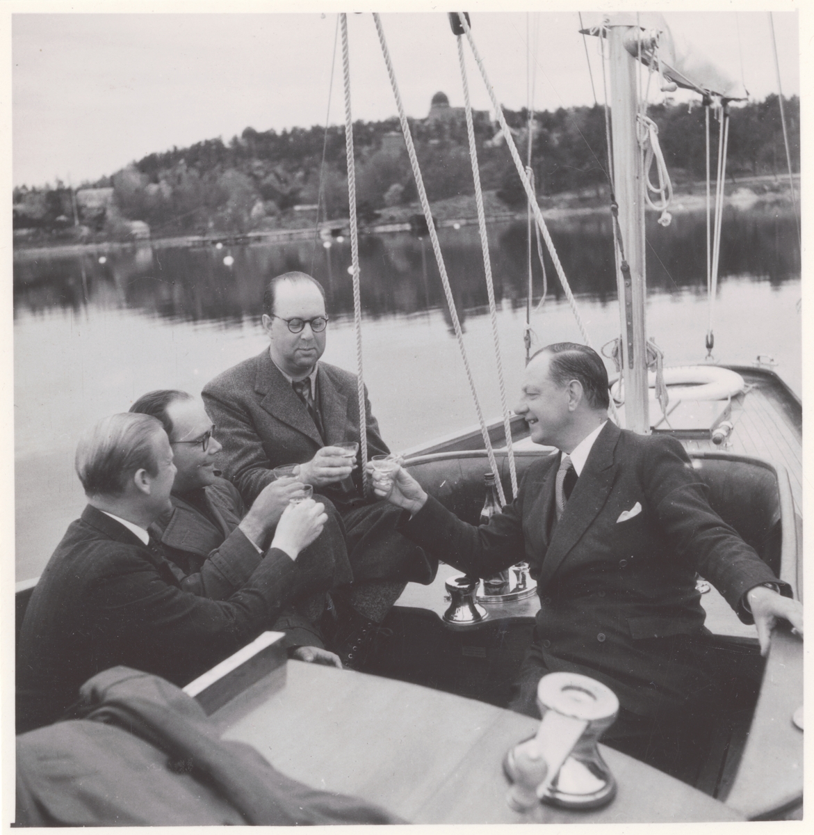 Gösta Åhlén tredje personen från vänster, Roy Hähnel längst till höger i segelbåt med en flaska konjak.