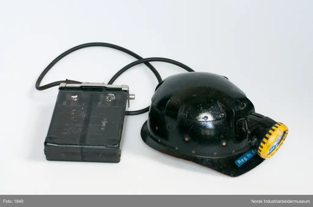 Vernehjelm med hodelykt og akkumulatorbatteri. Batteri og hodelykt er noe forbedret i forhold til 1950-utførelsen.