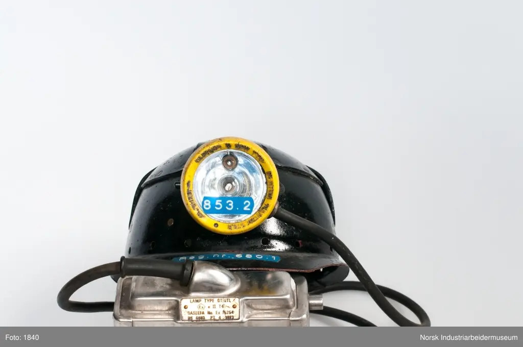Vernehjelm med hodelykt og akkumulatorbatteri. Batteri og hodelykt er noe forbedret i forhold til 1950-utførelsen.