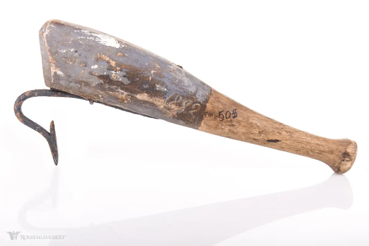 Klepp med solid skaft og krok. Øverste del av skaftet er blått, nederste er trehvit. Årstallet 1882 er malt inn på kleppen.