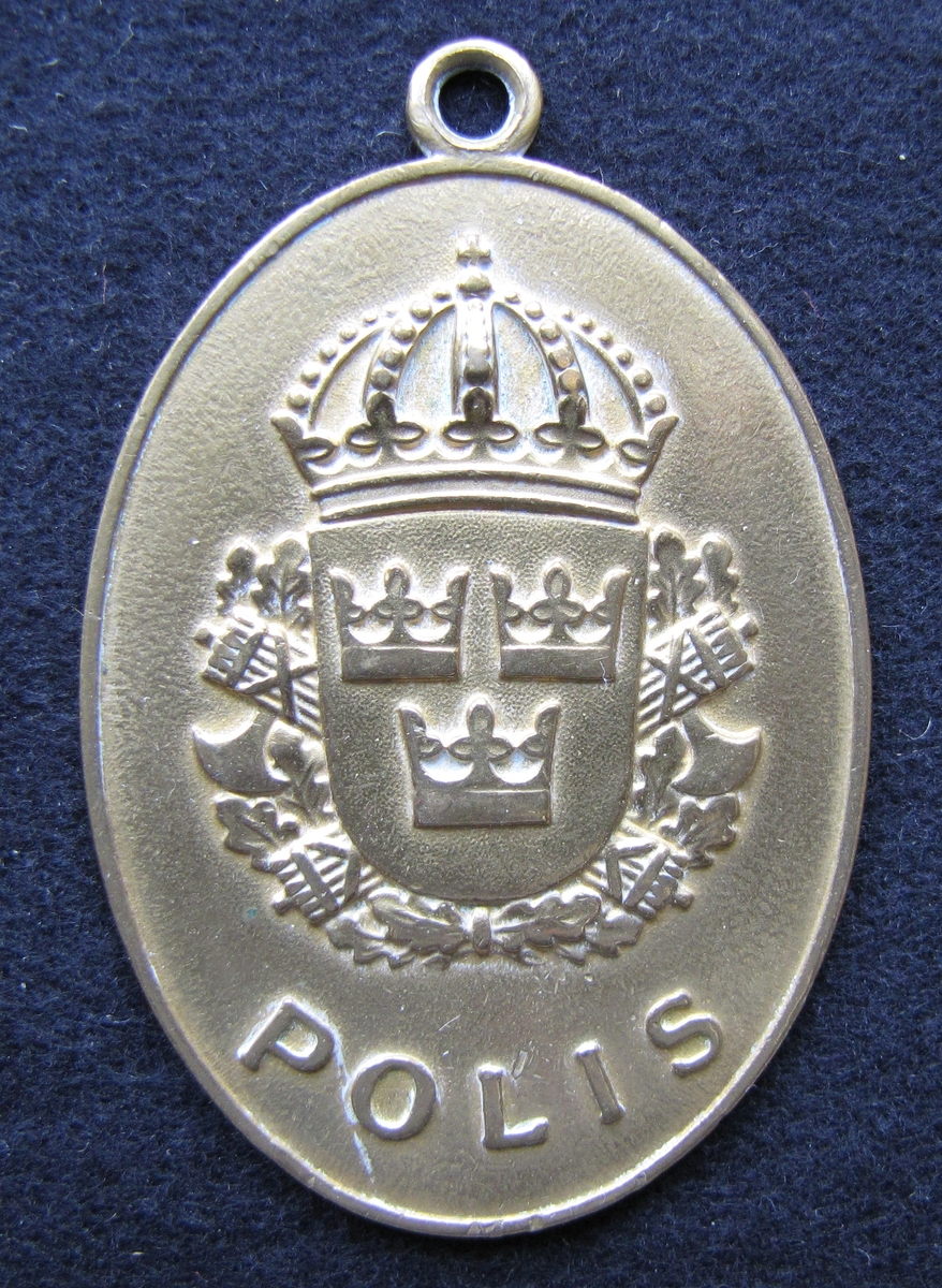 Polisbricka, oval med en ögla i toppen. 

På framsidan: Lilla riksvapnet, dvs en krönt sköld med tre kronor. Bakom skölden eklöv och korslagda fasciner. Under emblemet står det POLIS.

På frånsidan: VÄNERSBORGS POLISDISTRIKT står den i det övre och undre kanten. Mitt på står KRIMINALPOLISEN och siffran 6. Även tillverkaren Sporrong & CO, Stockholm finns ingraverat.