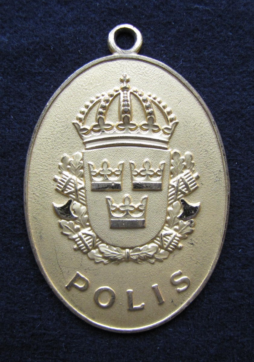 Polisbricka, oval med en ögla i toppen. 

På framsidan: Lilla riksvapnet, dvs en krönt sköld med tre kronor. Bakom skölden eklöv och korslagda fasciner. Under emblemet står det POLIS.

På frånsidan: STATSPOLISEN står den i det övre kanten. Mitt på står NR. 1271. Även tillverkaren Sporrong & CO, Stockholm finns ingraverat.