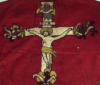 På mässhakens framsida finns en korsformad besättning av vävda guldband. Ryggsidan har även den en korsformad besättning, vilken föreställer Kristus på korset. På korsarmarna finns evangelisternas sinnesbilder. I nedre kanten av korset finns två förenade vapen och därunder en helgonbild. 

Enligt liggare:
"Messhake av rött siden med broderier från 1500-talet; Kristus på korset; på korsarmarna evangelisternas sinnebilder; under korset tvänne förenade vapen, därunder en helgonbild med Andreaskorset"


Neg.nr: 1984-04