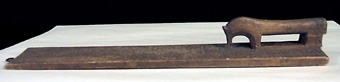 Mangelbräde med skulpterat, hästformat handtag. Karvsnittsdekor i form av rosett, virvelhjul, hjärta. Ristade bladornament, rutmönster mm. Uddsnittsbårder utmed långsidorna bl.a.