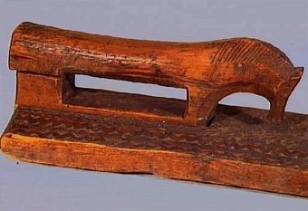 Mangelbräde med skulpterat, hästformat handtag. Karvsnittsdekor i form av rosett, virvelhjul, hjärta. Ristade bladornament, rutmönster mm. Uddsnittsbårder utmed långsidorna bl.a.