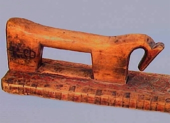 Mangelbräde med skulpterat handtag i form av en häst. Karvsnittsdekor bestående av hjärtan och rosettornament. Ornamenten omgivna av uddsnitt. Tandsnitt utmed långsidorna. Ena sidan av hästen märkt "ASO 1770", på den andra är "KSD" inbränt. Spår av röd målning på brädets ovansida.
