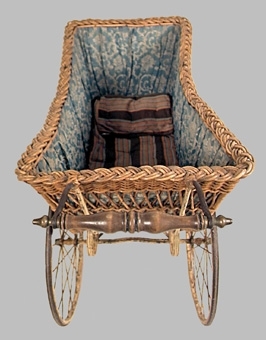 Barnvagn av korg, dvs flätad pil. Smalt profilsvarvat handtag. Insidan klädd med blåvitt, blommigt bomullstyg. Gulmålat stålunderrede med svarta ränder. 4 mycket stora hjul med ekrar, de bakre allra störst, i samma färger.
Använd vid barnens dagsfirande i Skara av släpvagnen Erik Sjöstrand, enligt äldre katalog.


Neg.nr: 82/439/10
Sakord: BARNVAGN
Tillverkningstid: 1900-1920
Material: PIL STÅL BOMULL
Teknik: FLÄTAT GJUTET SMITT
Mått: L=1070 B=490 H=900
Vikt: