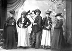 Fotot taget vid en Vita Liljans-fest.
Vita Liljan var en välgörenhetsförening.

Greta Bäckström är syster till fotografen .

Karin Bäckström f. 1880 drev fotoateljé på Vasagatan 5 i Töreboda. 
Hon tog över den av sin far Thure Bäckström, som hade etablerat firman 1886, och drev den 1896 -1916.
Karin Bäckström gifte sig år 1917 med John Knape.