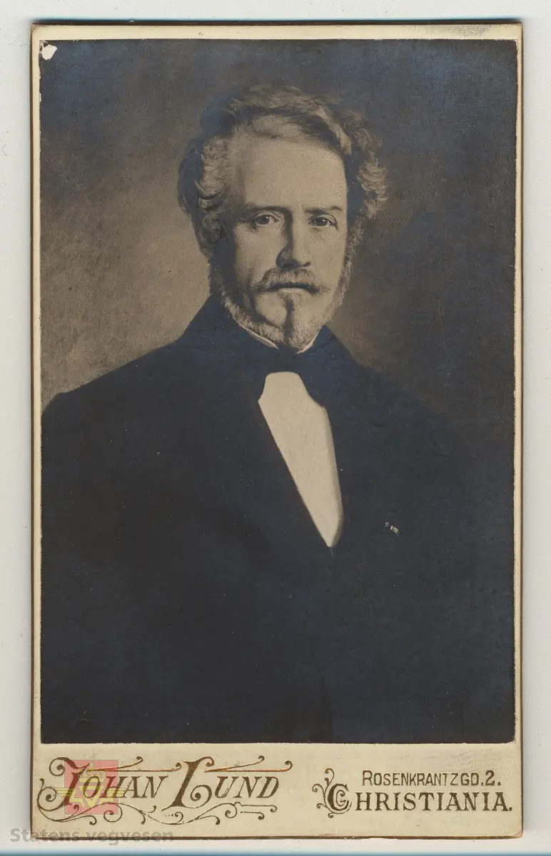 Håndskrevet tekst på framsiden av bildet: "Tilhører Baalsrud (Fra V.D. Krag) 1903." Videre medfølger det håndskrevet tekst til bildet: Sitat: "Krag og Vegdirektør Bergh prøver rullekjerre, bygget for billige veger." Bildet viser presentasjon av rullekjerren, som skulle bli det nye kjøretøyet for høyfjellsvegene, men ikke ble noen suksess. 
Dette bilde er vistnok tatt i et gårdsrom i Haugesund. Til venstre sitter daværende vegdirektør Bergh og til høyre seinere vegdirektør Krag. Usikkert når bilde er tatt, Christian Wilhelm Berg døde i 1873 så bildet er tatt før den tid, og det er trolig det eneste fotografiet vi kjenner hvor Christian W. Bergh er avbildet. Følg pilen til høyre for flere bilder. I alt 7 bilder.
Ref. til "Meddelelser fra Veidirektøren," nr. 2-1945, side 24, der bildet er illustrert i en artikkel om "Rullekjerren," av H.W. Paus. 
Ref. til "Årbok for Norsk vegmuseum 2016," en artikkel om Vegdirektør Krag - "Heller en tarvelig vei enn ingen vei," ved Ane Cecilie Røed. I boka er samme bildet side 101 som i "Meddelelser fra Veidirektøren," nr. 2-1945)
Utsnitt fra Ane Cecilie Røed sin artikkel:
Rullekjerren
"Som vegmann var Krag opptatt av nye ideer og initiativ for å bedre framkommeligheten. Han var også interessert i ulike framkomstmidler noe denne historien illustrerer. Befolkningen i Skjåk hadde lenge ønsket seg en kjøreveg over fjellet til Vestlandet, og da gjerne til Tafjord. Krag på sin side ville at vegen, en simpel kjøreveg, skulle gå over Grotli og slik ble det. Da vegen var nesten ferdig, viste det seg at man ikke kunne kjøre på den med vogn. Til det var vegdekket for løst og vegen for smal. En rullekjerre, som enten var en kjerre med to brede hjulfelger, eller en trommel eller rulle, ble lansert og ble begeistret støttet av Krag.  Det sies om rullekjerren at den allerede i begynnelsen hadde det med å løpe løpsk og rulle sine passasjerer omkull. Da vegdirektøren og ordføreren skulle prøvekjøre den nye farkosten, endte de i grøften, med bygdefolket som nysgjerrige tilskuere. Kort tid etter var rullekjerren en saga blott, og på den nye vegen kjørte man med bredfelgede kjerrer (Schulerud 1974 s 301-302). Historien om rullekjerren bekrefter på lik linje med andre episoder i denne artikkelen, Krags brede interessefelt og engasjement. "
Se artiklene i Nedlastinger og Referanser lenger ned på siden.
Et eget Vegdirektorat kom først i 1864, og Christian Wilhelm Berg var den første vegdirektør i perioden 1864 - 1873.
Etterfulgt av  Hans Hagerup Krag i 1874 - 1903,  Johan Christian Skougaard 1903 - 1918 og Andreas Baalsrud i perioden 1919 - 1945. 
Bilde 2) Vegdirektør Christian Wilhelm Bergh.  Bilde 3) Vegdirektør Hans Hagerup Krag. Bilde  4) Vegdirektør Johan Christian Skougaard. Bilde 5) Vegdirektør Andreas Baalsrud. Se vedlegg i Nedlastinger for mer informasjon.
Bilde 6) Rullekjerren.  I følge «Meddelelser fra Veidirektøren Nr. 2-1945, side 24, er dette bilde av rullekjerren tegnet av overingeniør Fenger Krog.
Bilde 7) Informasjon om rullekjerren ved Norsk vegmuseum sin første utstilling 1992.