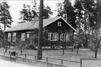 Svanvik, Hultets småskola 1951 - 1963. Exteriörbild. I trädgården lärare Maja Bylund. Förstoring 37 x 53 cm. Neg finns.