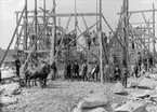 Vara socken. 
Vara kyrka under byggnad, invigd 1902. 
Mannen i vitt skägg är apotekare Fritjof Lilja, en av tillskyndarna för att Vara köping skulle få egen kyrka.