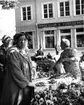 Skara. 
Torgdag på Skoltorget.

Greta Ahlborg, främst.
Ev. Vega Tranberg som försäljare.

Skoltorget = Grönsakstorget