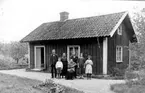 Familj framför torpstuga