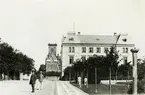 Järnvägsgatan vid mitten av 1880-talet.
I samband med tillkomsten av Lidköping - Skara - Stenstorps Järnväg i början av 1870-talet öppnades 1872-1874 från Stora torget till stationen en gata, som fick namnet Järnvägsgatan.
Åren 1874 och 1875 uppbyggdes vid dennas östra sida Stadshotellet å bilden, vilket senare undergått en del förändringar. I fonden ses läroverksbyggnaden och bakom denna det enda av kyrkans då kvarstående huvudtorn.