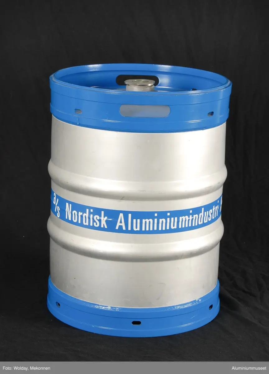 Teknikk: Fatet er presset som to sylindriske halvdeler.Trillevulsene er presset ut med gummi. Halvdelene er renkappet, hull for anstikker er lokket og de er beiset. Midtsveisen er TIG-sveiset i en automat og  fire ringsveiser er MIG-sveiset samtidig i en annen automat. Bunn- og toppring, med stablekanter er fremstilt av Al-profil. De er lokket i eksenterpresse og rundvalset. De er TIG-sveiset og slipt.
Fatene ble levert lakkert etter kundens ønske.
Form: Sylindrisk form
