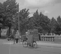 Pojke med lådor med text A-B NYA BAGERIET på cykeln på Kungsbron över Gavleån.