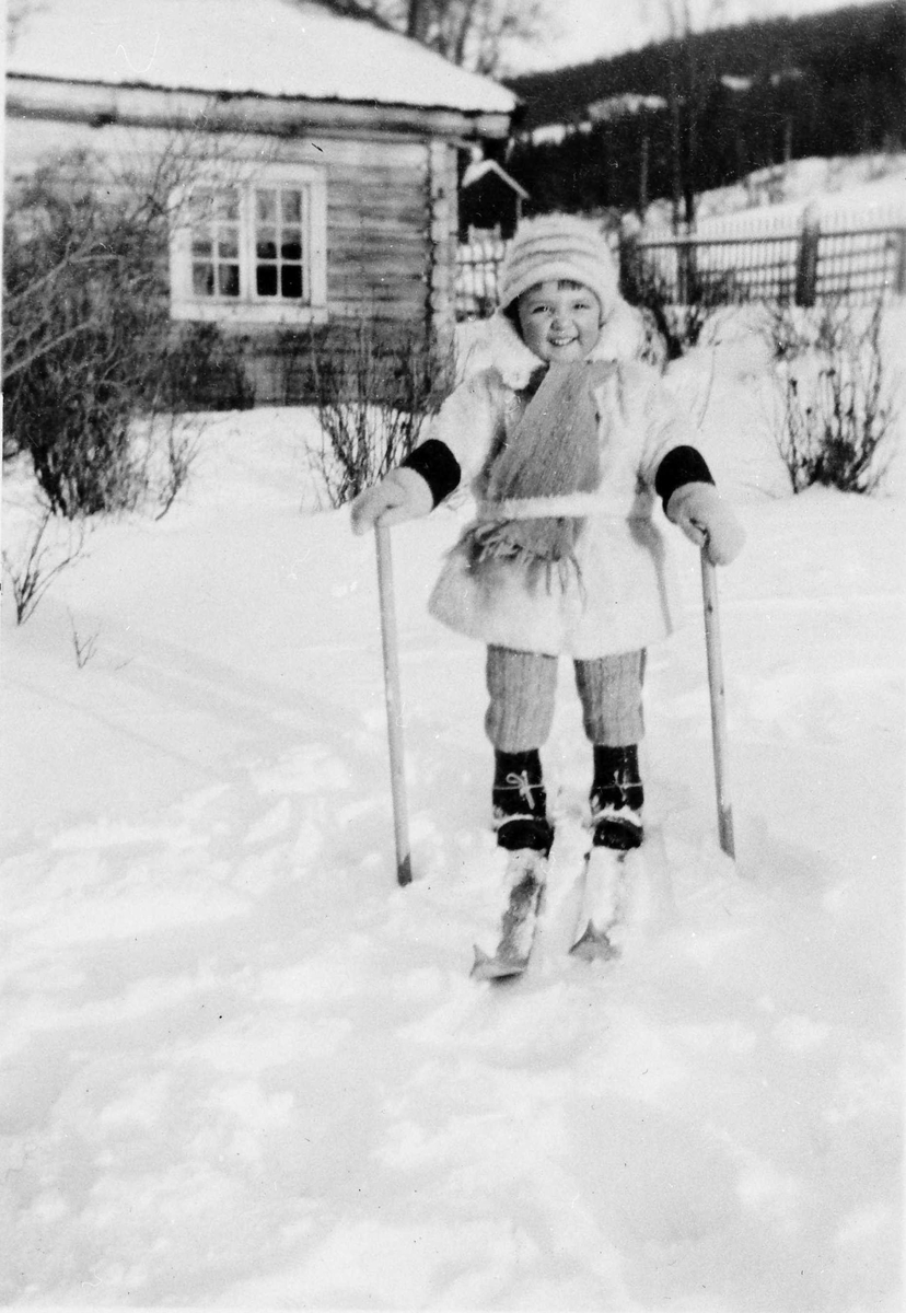 Barn, klær, ski og skistaver, bolighus. 