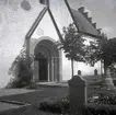 En kyrka, portal och gravstenar.