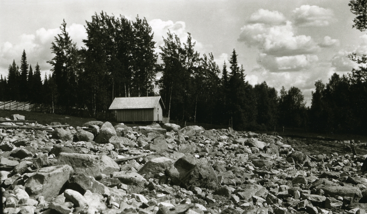 Steinbrudd i forgrunnen. Lite hus (uthus) midt i bildet. Galåsen.