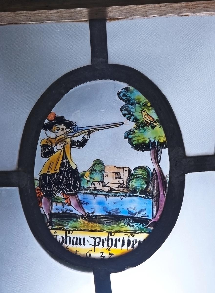 Fönster, med tre målade glas: en man som skjuter mot en fågel i ett träd; en kvinna vid spinnrock; Kristi korsnedtagning. De ha följande text: Johan Pehrssen 1632; Margareta Pehrssen 1632; 1626.
Målningarna (ovaler) äro 13,5x17cm.
Från Nor, Storviks Hammarby, Ovansjö sn, urspr. i en gård i Stocksbo by, Ovansjö. Den förste nybyggaren i Stocksbo var Pehr Andersson; efter honom nämnes som ägare Johan Pehrsson, som sannolikt är P.A.s son. J.P. var gift 2ggr, andra ggn m. Marit Pehrsdotter, d. 1656.