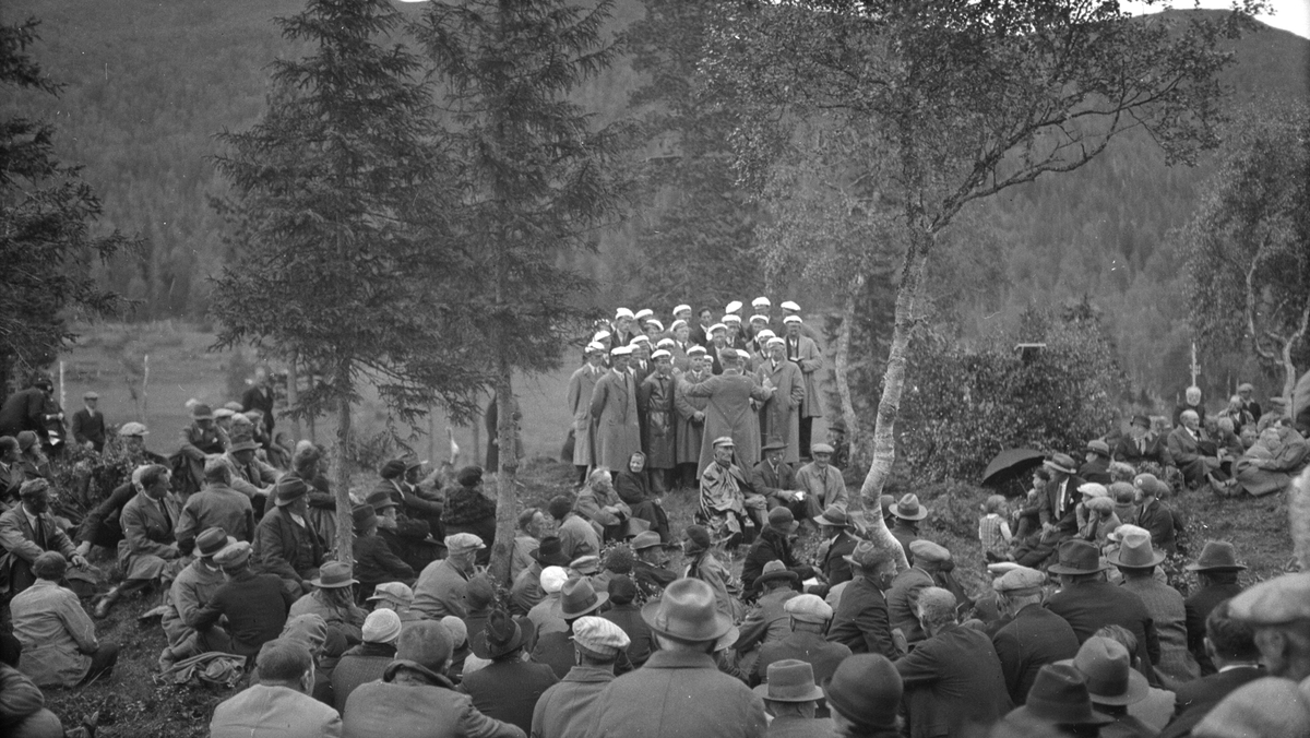 Bondestevne på Majavatn på 1934. Mye folk sittende i skogen. Sangkor.