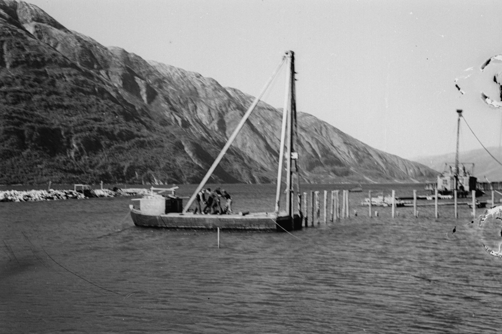 Under anleggsperioden på Jernbanekaia. "Pæling" i forbindelse med oppfylling. Menn i arbeid på Flåte/båt med pæleutstyr.