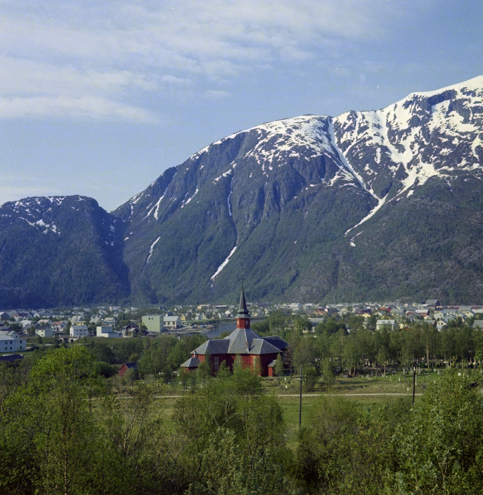 Dolstad kirke med byen og Øyfjellet i bakgrunnen.