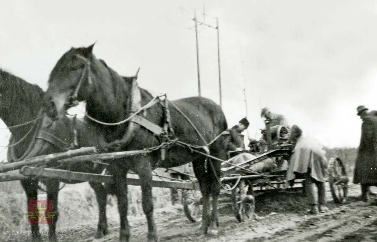 Amerikansk veghøvel "Russel Grader"  i arbeid i Østfold 1924, i følge merking.  Ref. til "Meddelelser fra Veidirektøren", Nr. 47-mai 1924. Artikkel om "Prøve med den amerikanske veihøvel "Russel Grader" samt skrapning av veibanen med "Western" skrape", av overingeniør Thor Olsen. Befaring  med vegdirektoratets og Østfold fylkets ingeniører.  Andre bilder av veghøvelen som er illustrert i artikkelen vises i bilde 2/5 og 3/5. Bilde 4/5: "Skraperne av "Western"-typen forarbeides som nævnt ved fylkets verksted og utstyres nu med en fast arm paa den ene side for styring av hele redskapen foruten den bevægelige for stillingen av bladene , som det vil sees av fig. 5". Bilde 5/5: Vedlikeholdsarbeid med amerikansk vegskrape utføres i Østfold.