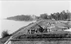 Artilleriet, skjutning från skjutplatsen vid Vätterstranden. Järnvägsspår syns vid sjökanten.