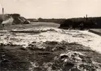 Avesta järnverk vid Avetsaforsen. Fotografiet taget från landsvägsbron. Till vänster, Månsbo Kloratfabrik, till höger, järnverket.