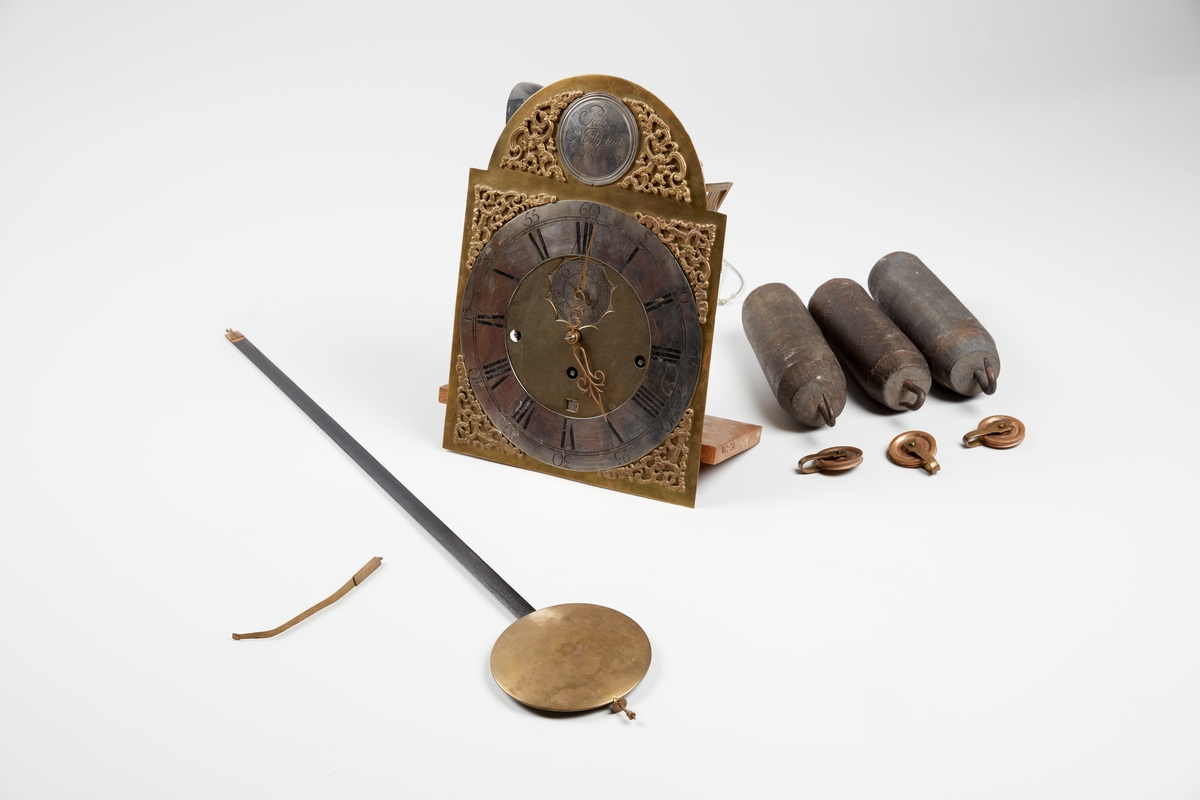 Gulvur i antatt sekundær kasse. Buet toppstykke med brutt gavl og vinduer til urverket på sidene. Rektangulær hoveddel med svungen sokkel nederst. Toppstykket dekorert med utskåret gitterverk øverst samt tre kuler på gesimsen og søyler på hver side av lysåpningen. Hoveddelen av kassen med pendeldøren er udekorert, sokkelen dekorert med utskåret gitterverk samt blader (akantus) på sidene og musling på midten nederst. Hele kassen malt ensfarget rød, kulene på gesimsen er sorte.

Urverk av messing forsynt med spillverk med elleve bjeller (visstnok til to melodier) samt én timeslagbjelle. Støpt dekor i tallskivens hjørner, hovedsakelig bladverk og c-formede ornamenter i et intrikat mønster. Midtfeltet er finhamret uten annen ornamentikk. Forsølvet timering og stjerneformet sekundring samt navneplate med signatur øverst og datoring som vises over sekstallet nederst.