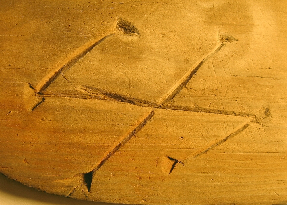 En svepask, i delar. Delarna utgörs av ett lock, en botten samt fragment av svepet. Locket och botten är båda försedda med varsitt bomärke.