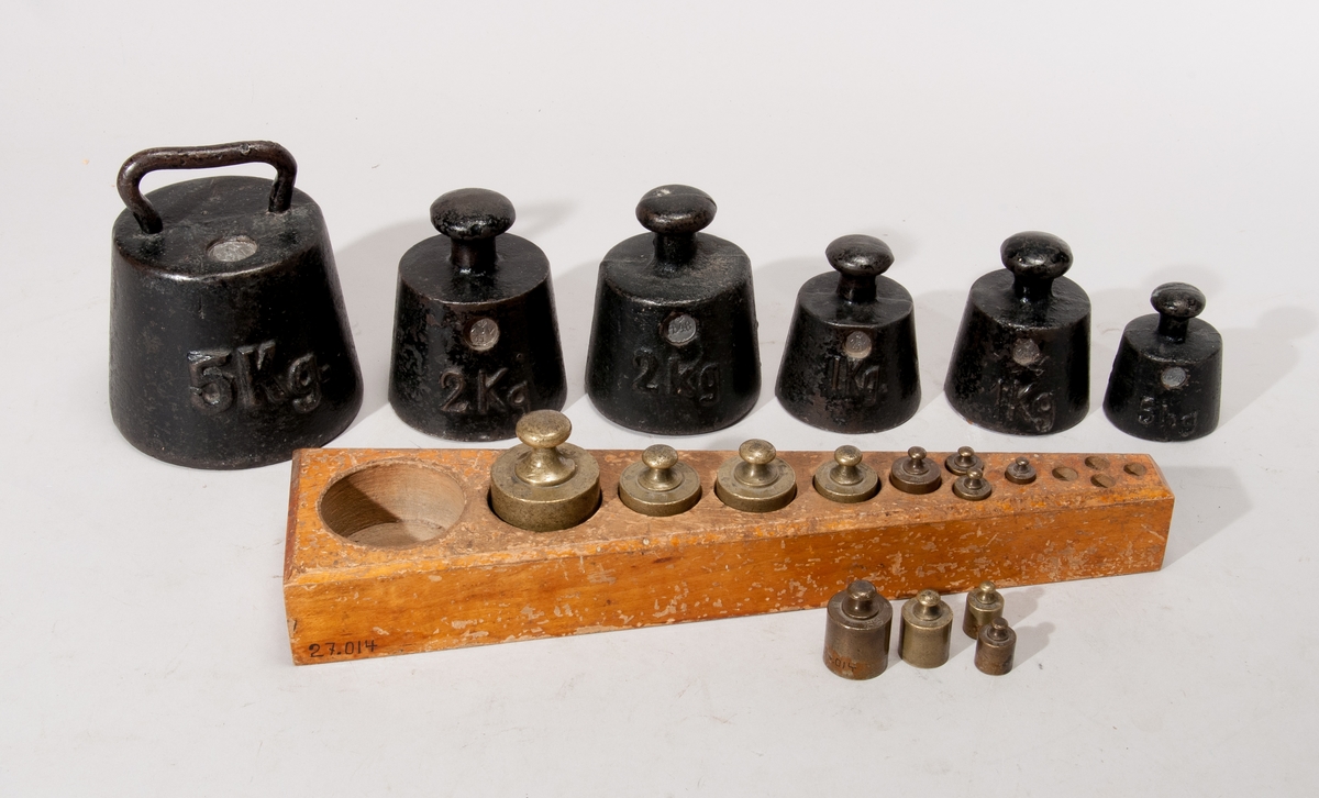 19 st. vikter, 5 kg-5 hg av gjutjärn, 5 hg-10 g av mässing jämte ställpatta av trä, krönta åren 1899-1941. Vikter 5.2 och 1 g saknas. 
Vikter svarta 
1 st. 5 kg, 
två st. 2 kg, två st. 1 kg, 5 hg. Vikter av mässing i viktbräde: 5 hg, två st. 2 hg, 
två st. 1 hg, två st. 50 gr, fyra st. 20 gr, 10 gr. Flertalet av vikterna är märkta MJV = Mynt- och Justeringsverket.