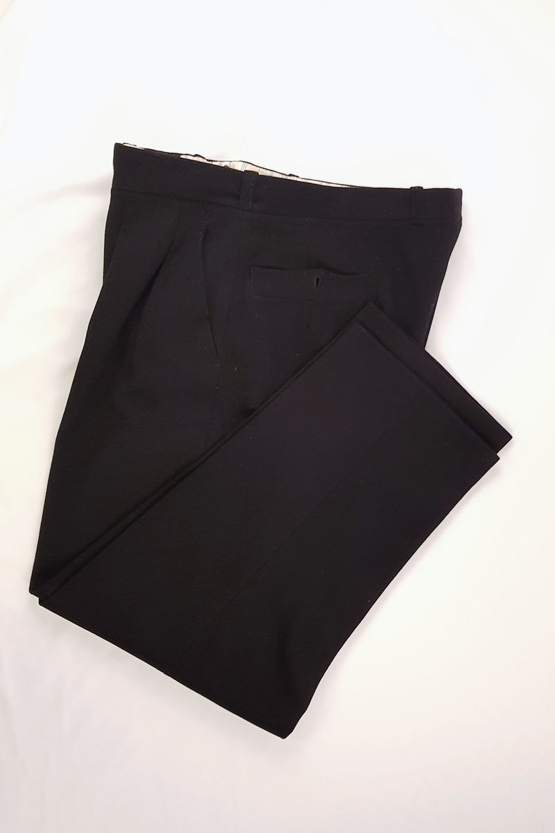 Norsk kapteinsuniformuniform bestående av bukse, jakke og lue i marineblått ullstoff. Jakken har tre gullstiper og diamant, noe som tilsier at dette er en kapteinsuniform.