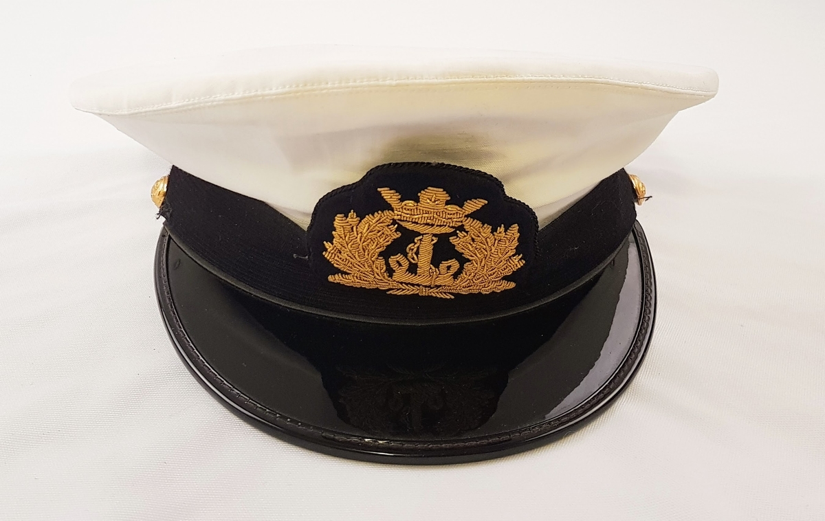 Norsk kapteinsuniformuniform bestående av bukse, jakke og lue i marineblått ullstoff. Jakken har tre gullstiper og diamant, noe som tilsier at dette er en kapteinsuniform.