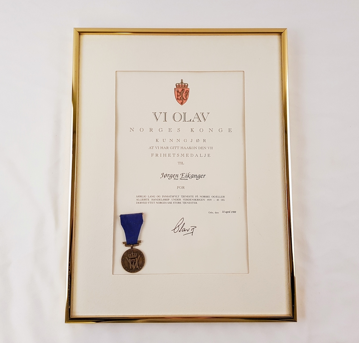 Diplom og Haakon den VII frihetmedalje i ramme med glass.