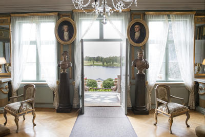En av stuene i hovedbygningen på Bogstad gård. En dør står åpen ut mot hagen og Bogstadvannet.  