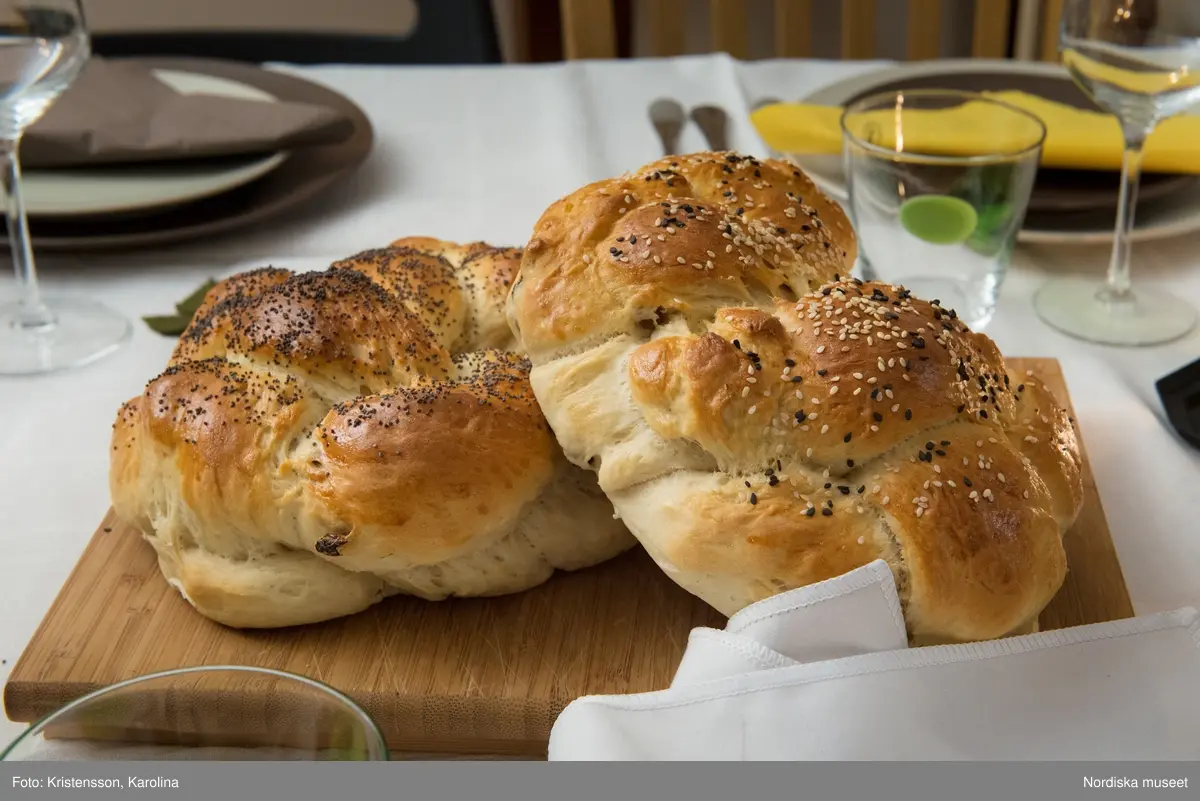 Rosh Hashana. Maten på ett judiskt nyårsbord: granatäpple, honung, bröd, äppelskivor, hummus, aubergine- och tomatröra, I köket: köttgryta (Hammin??) med sötpotatis, blomkål med citron, kycklingklubbor, ingefärssoppa, kryddris med linser och russin.