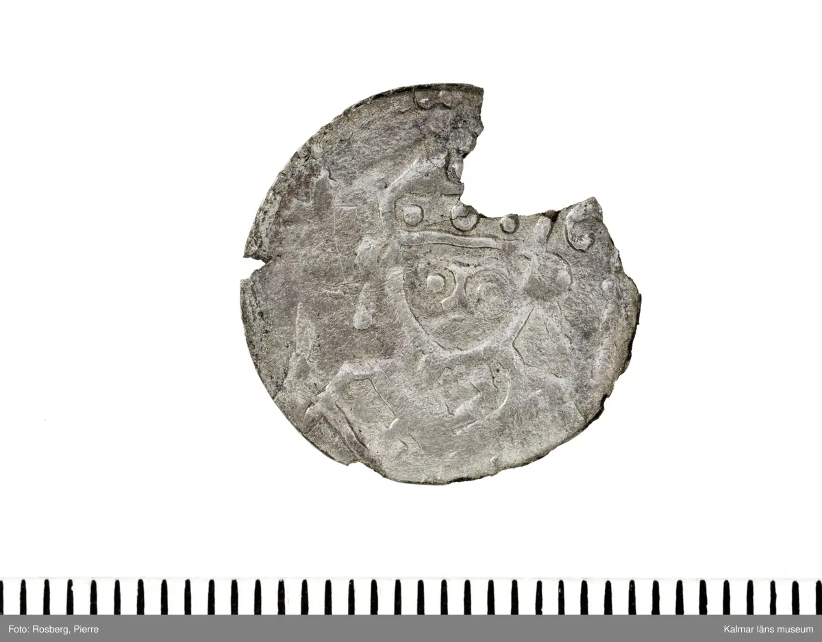 KLM 14507 Myntfynd, ett armband, bildat av silvermynt. Armbandet består av åtta infällda mynt, varav ett har lossnat från sin inramning. Mynt från Valdemar I:s tid, samt ärkebiskop Absalon, 1100-talets slut. Mynten i armbandet härstammar från ett jordfynd av ca 30 stycken likadana mynt, hittade i jorden på Åby prästgårds ägor omkr 1885. Av de nu befintliga åtta stycken, är präglade för Knut VI, Lund
