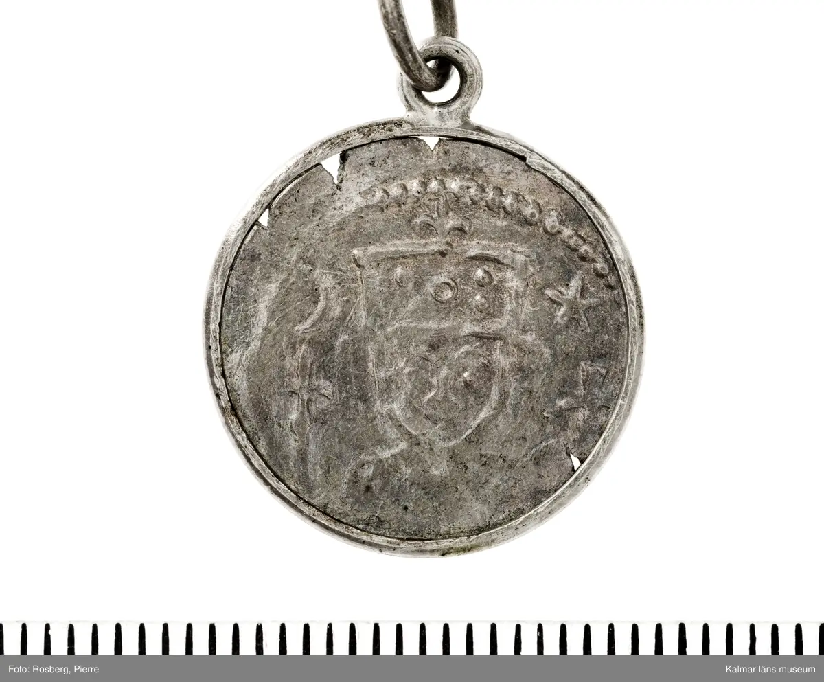 KLM 14507 Myntfynd, ett armband, bildat av silvermynt. Armbandet består av åtta infällda mynt, varav ett har lossnat från sin inramning. Mynt från Valdemar I:s tid, samt ärkebiskop Absalon, 1100-talets slut. Mynten i armbandet härstammar från ett jordfynd av ca 30 stycken likadana mynt, hittade i jorden på Åby prästgårds ägor omkr 1885. Av de nu befintliga åtta stycken, är präglade för Knut VI, Lund