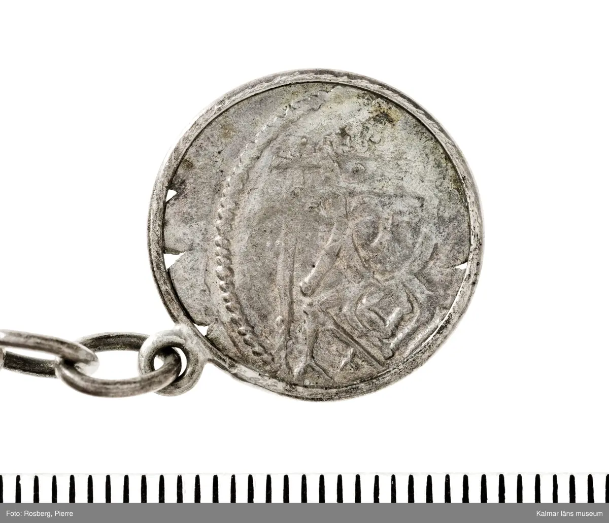 KLM 14507 Myntfynd, ett armband, bildat av silvermynt. Armbandet består av åtta infällda mynt, varav ett har lossnat från sin inramning. Mynt från Valdemar I:s tid, samt ärkebiskop Absalon, 1100-talets slut. Mynten i armbandet härstammar från ett jordfynd av ca 30 stycken likadana mynt, hittade i jorden på Åby prästgårds ägor omkr 1885. Av de nu befintliga åtta stycken, är präglade för Knut VI, Lund